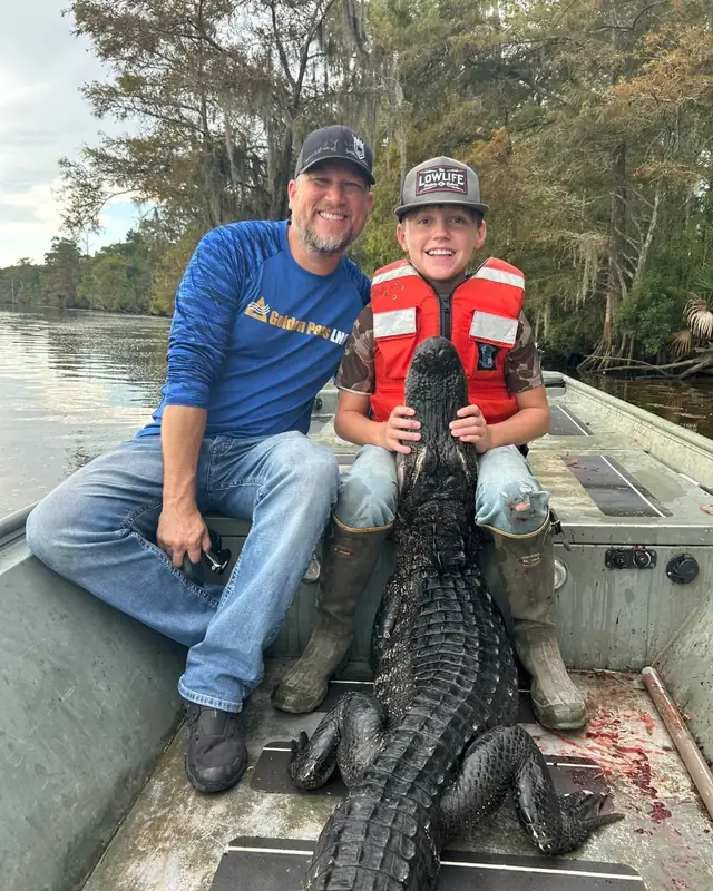 Father and son in a jon boat on a family alligator hunt in Louisiana