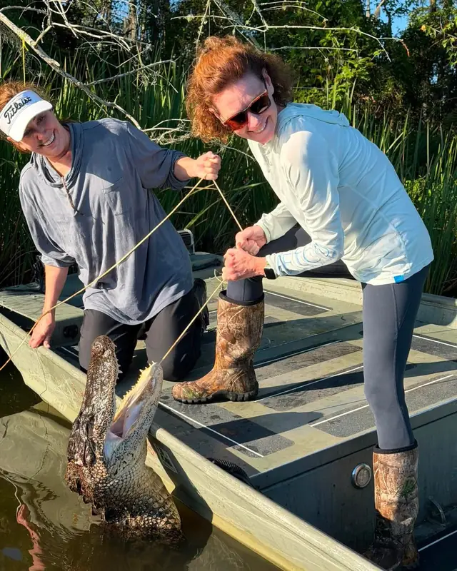 Two hunters landing an alligator during a guided Louisiana hunt