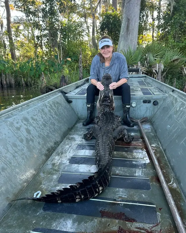 Hunter with a full length alligator laid out in the boat